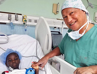 Le Dr Gérard Babatasi au chevet d'un enfant à la suite d'une opération cardiaque