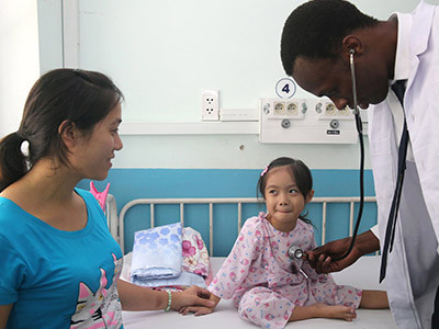 Un enfant vietnamien lors d'une consultation médicale réalisée par un médecin burkinabé