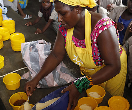 Une "maman cantine" sert les repas des élèves au Togo