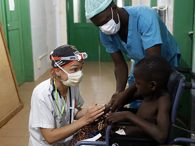 Un médecin bénévole de La Chaîne de l'Espoir rassure un enfant avant son opération