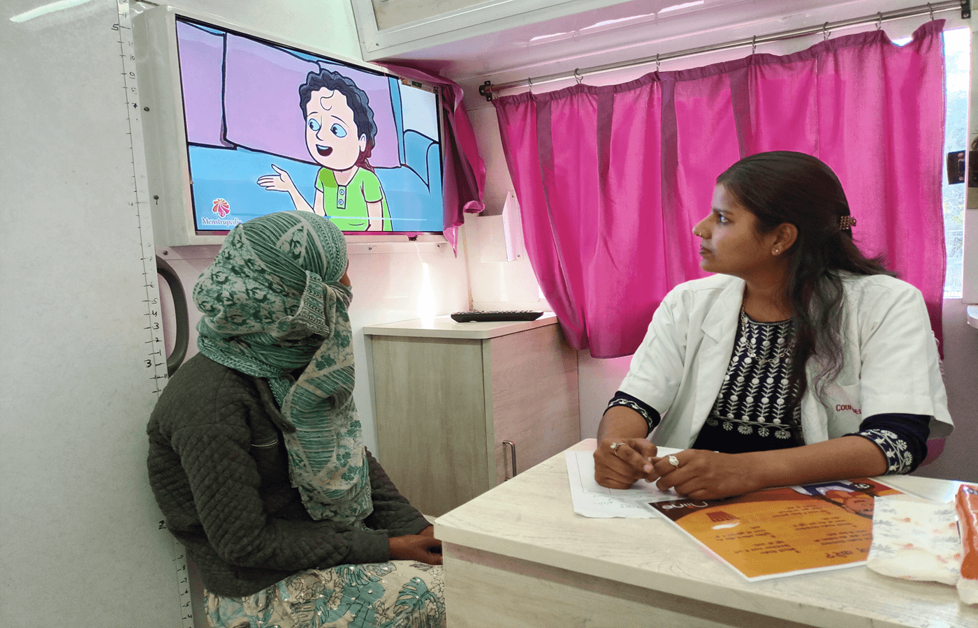 En Inde, dans la clinique mobile de Taabar, une jeune fille assiste à une séance de sensibilisation à l’hygiène menstruelle diffusée sur écran télé